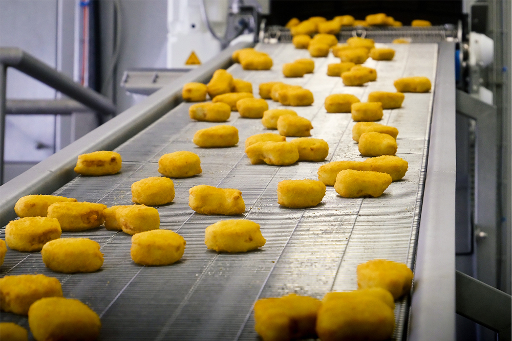 Chicken Nuggets im Auslauf Abförderband des Spiral Ofens alco food machines